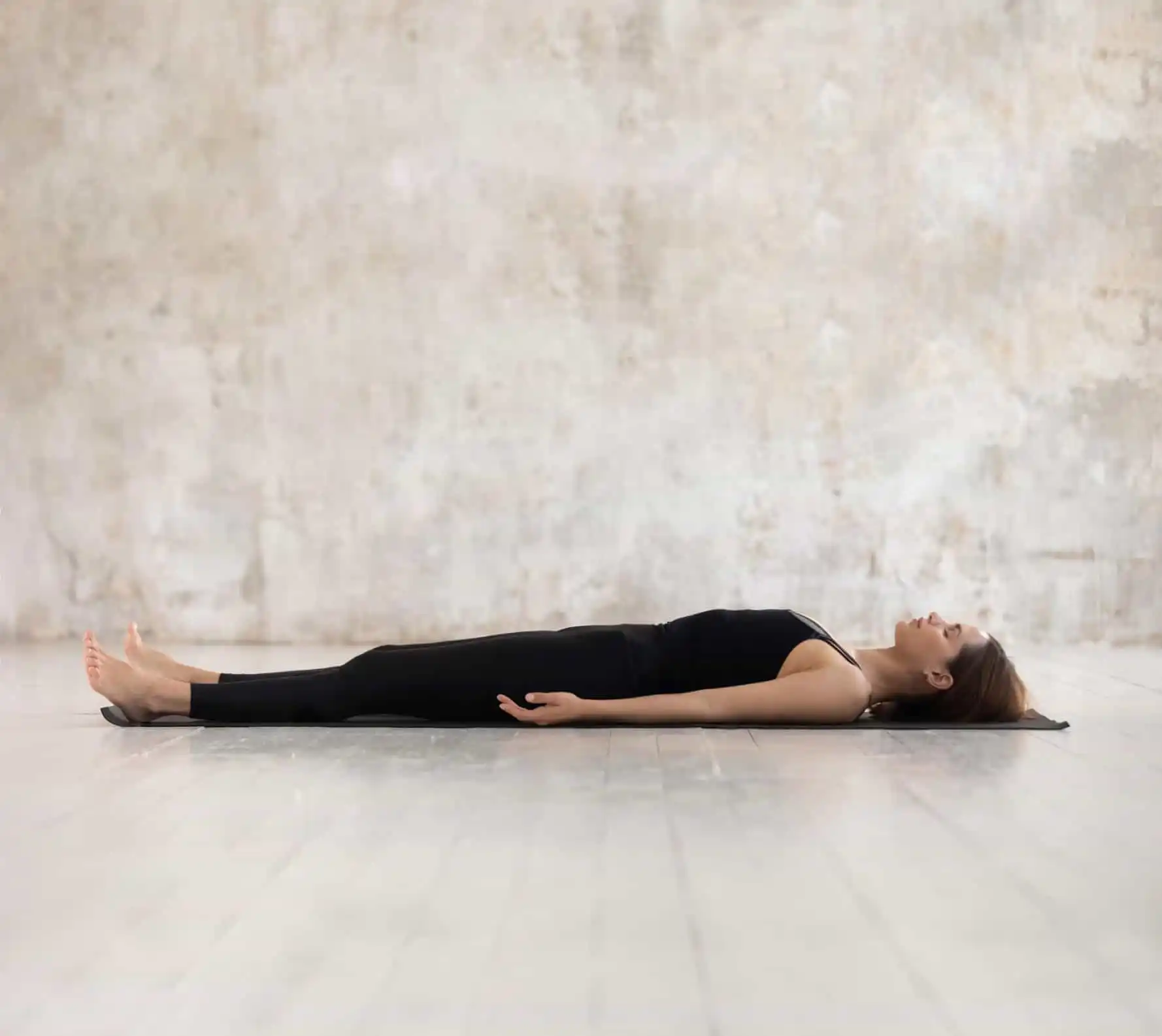 Sudionica ATM lekcije leži na podu za vrijeme Feldenkrais sesije